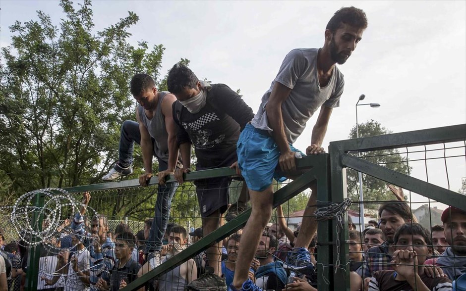 Ουγγαρία - μετανάστες - συγκρούσεις. Μετανάστης σκαρφαλώνει στον φράχτη που έχτισε η Ουγγαρία στα σύνορά της με την Σερβία. 