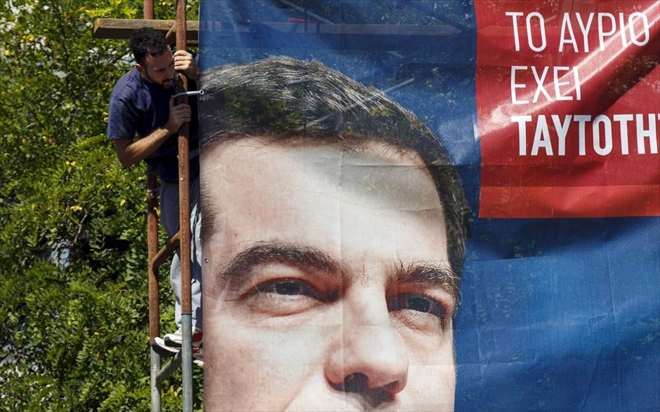 Μια «ανάσα» πριν την κάλπη. Εργάτης κοιτά προεκλογική αφίσα με το πρόσωπο του προέδρου του ΣΥΡΙΖΑ, Αλέξη Τσίπρα στο κέντρο της Αθήνας. Στις κάλπες προσέρχονται αύριο 9,8 εκατομμύρια Έλληνες, προκειμένου να αναδείξουν την επόμενη κυβέρνηση της χώρας, η οποία θα κληθεί να εφαρμόσει μία σειρά δύσκολων μεταρρυθμίσεων, με στόχο την έξοδο της χώρας από την κρίση. Σύμφωνα πάντως, με τις δημοσκοπήσεις που είδαν την Παρασκευή το φως της δημοσιότητας, η δεξαμενή των αναποφάσιστων και της αποχής φαίνεται πως είναι εκείνες που θα κρίνουν τη διαφορά του πρώτου από τον δεύτερο.