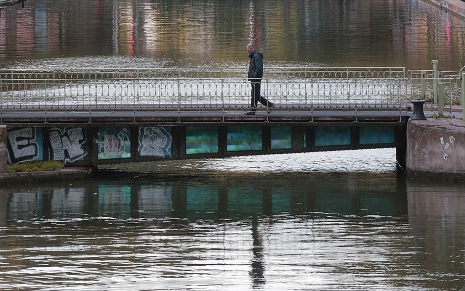 Απόγευμα στο Παρίσι. Άνδρας διασχίζει γέφυρα στο Κανάλι Σαιν-Μαρτέν, στο Παρίσι.
