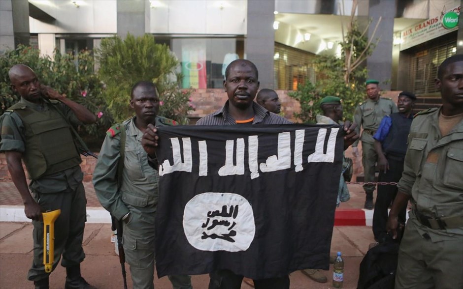 Μάλι - τρομοκρατικό χτύπημα. Αστυνομικοί κρατούν τη σημαία του Ισλαμικού Κράτους, η οποία ανήκε στους ενόπλους που εισέβαλαν στο ξενοδοχείο Radisson. 