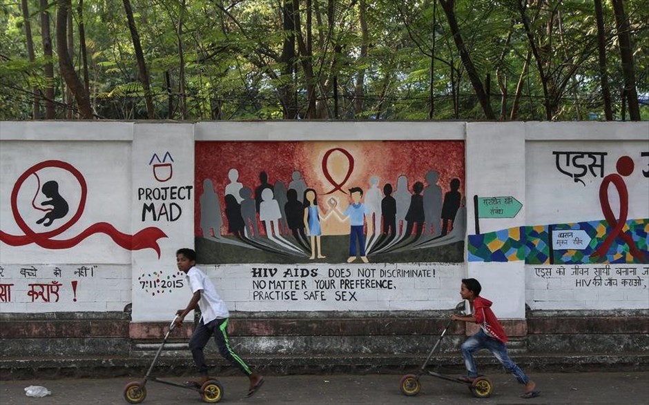 Παγκόσμια Ημέρα κατά του AIDS. Παιδιά τρέχουν μπροστά από τοιχογραφία με θέμα το AIDS στη Μουμπάι της Ινδίας. Σύμφωνα με έκθεση του Οργανισμού Ηνωμένων Εθνών, υπολογίζεται πως 50.000 έφηβοι ηλικίας 15 ως 19 ετών μολύνθηκαν από τον HIV πέρυσι στην περιοχή Ασίας-Ειρηνικού.