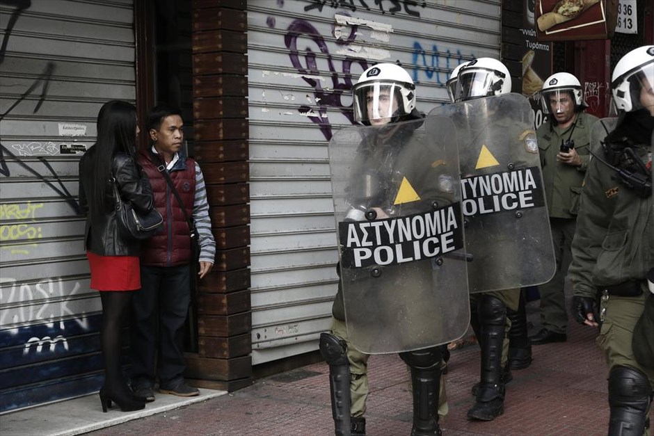 Πορεία - Γρηγορόπουλος . Τουρίστες παρατηρούν τους αστυνομικούς που περπατούν παράλληλα με τους διαδηλωτές.