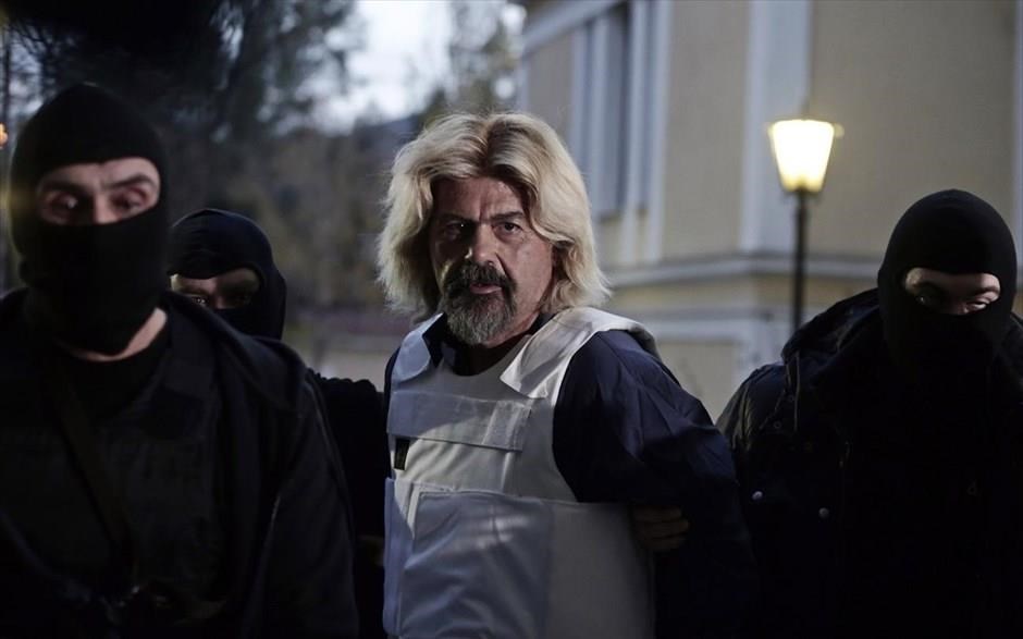 POY 2015 - Ιανουάριος. Ο Χριστόδουλος Ξηρός οδηγείται στον εισαγγελέα, υπό ισχυρή αστυνομική προστασία το απόγευμα της 4ης Ιανουαρίου. Ο Χριστόδουλος Ξηρός συνελήφθη την προηγούμενη ημέρα στην Ανάβυσσο. Είχε βαμμένα ξανθά τα μαλλιά του και το μούσι του, και παρόλο που οπλοφορούσε δεν προέβαλε αντίσταση κατά τη σύλληψή του.