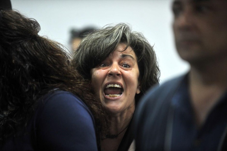 POY2015 - Μάιος. Η μητέρα του Παύλου Φύσσα, Μάγδα,&nbsp;φωνάζει, ιδιαίτερα φορτισμένη, προς την πλευρά των κατηγορουμένων, ύστερα από ανακοίνωση της προέδρου του δικαστηρίου&nbsp;για διακοπή της δικής της Χρυσής Αυγής λόγω ανεπαρκών μέτρων ασφαλείας. (15 Μαΐου).