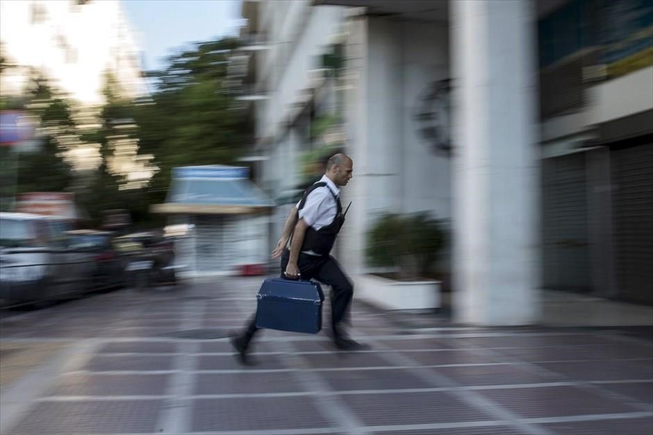 POY2015 - Ιούνιος. Υπάλληλος εταιρείας σεκιούριτι μεταφέρει χρήματα σε υποκατάστημα της Εθνικής Τράπεζας στο Σύνταγμα (28 Ιουνίου). Προβλήματα στην τροφοδοσία των ΑΤΜ λόγω αυξημένων εκροών παρατηρήθηκαν μετά την ανακοίνωση του Πρωθυπουργού, μία ημέρα νωρίτερα, για τη διεξαγωγή δημοψηφίσματος στις 5 Ιουλίου.