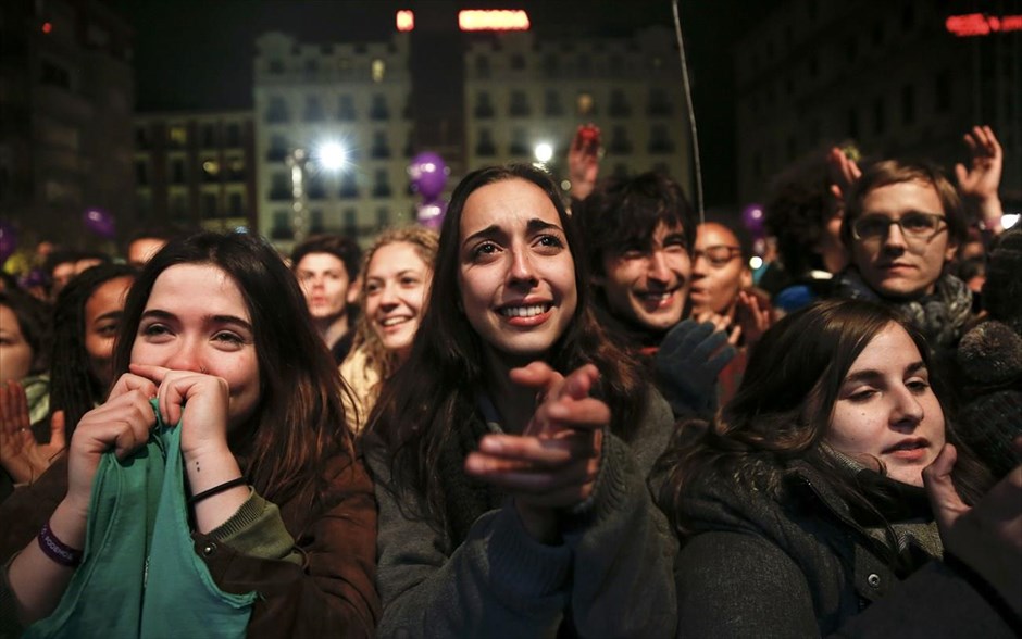 Αλλαγή του πολιτικού τοπίου μετά τις εκλογές στην Ισπανία. Υποστηρικτές του&nbsp;Podemos παρακολουθούν την ομιλία του επικεφαλής του κόμματος,&nbsp;Πάμπλο Ιγκλέσιας, μετά την ανακοίνωση των αποτελεσμάτων των εκλογών στην Ισπανία. Μετά την καταμέτρηση του 100% των ψήφων, το Λαϊκό Κόμμα έλαβε 28,72% των ψήφων και 123 έδρες.&nbsp;Η πολιτική της λιτότητας που ακολούθησε η κυβέρνηση του Ραχόι, όπως και ένα σκάνδαλο διαφθοράς που ξέσπασε στο κόμμα ευνόησαν την ανάδειξη των δύο νέων κινημάτων, του Podemos της ριζοσπαστικής αριστεράς και των φιλελεύθερων Ciudadanos, τα οποία εξασφάλισαν&nbsp;αντίστοιχα 69 έδρες (20,6% των ψήφων) και 40 έδρες (14% των ψήφων).