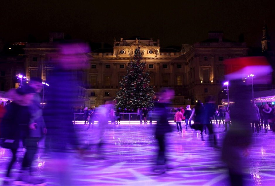 Χριστούγεννα στον κόσμο. Κόσμος κάνει πατινάζ μπροστά στο χριστουγεννιάτικο δέντρο που βρίσκεται στο Σόμερσετ Χάουζ του Λονδίνου. 