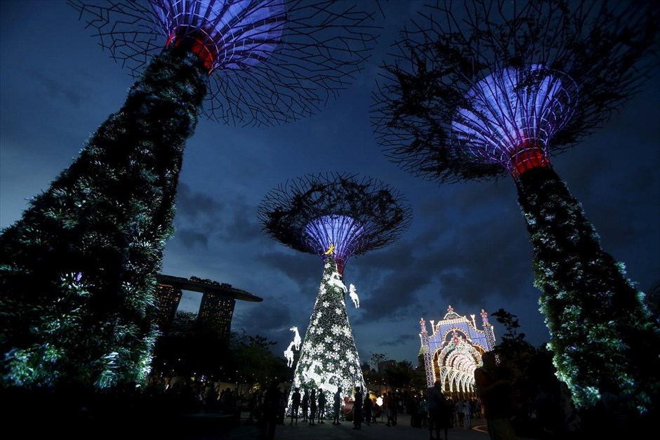 Χριστούγεννα στον κόσμο. Χριστουγεννιάτικοι στολισμοί στα ηλιακά «υπερδέντρα», τα οποία λειτουργούν ως κρεμαστοί κήποι, στη Σιγκαπούρη.
