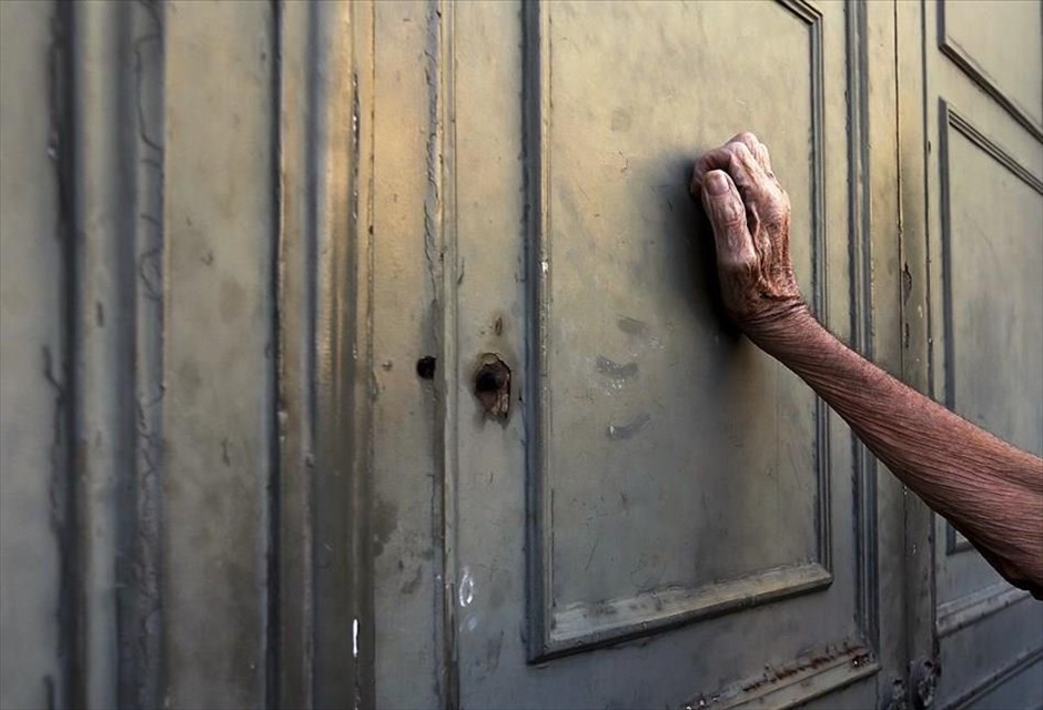 POY2015 - Ιούλιος. Συνταξιούχος στηρίζεται στην πόρτα υποκαταστήματος της Εθνικής Τράπεζας, καθώς περιμένει να ανοίξει προκειμένου να εξυπηρετηθεί, κατά την περίοδο της ειδικής τραπεζικής αργίας (6 Ιουλίου).