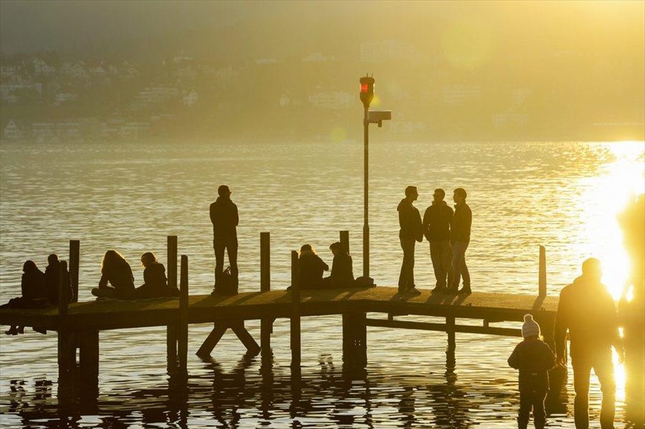 Ηλιόλουστο απόγευμα στη Ζυρίχη. Κόσμος απολαμβάνει τη λιακάδα στην όχθη της λίμνης, στη Ζυρίχη.