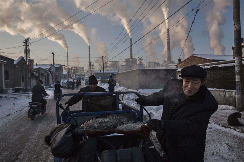 Βραβεία World Press Photo 2016. Φωτογραφία του Καναδού Kevin Frayer για το πρακτορείο Getty Images, στην οποία απονεμήθηκε το πρώτο βραβείο για την κατηγορία «Daily Life». Στη φωτογραφία διακρίνονται άνδρες να μετακινούν ένα τρίκυκλο σε γειτονιά της επαρχίας Shanxi στην Κίνα, στις 26 Νοεμβρίου 2015.