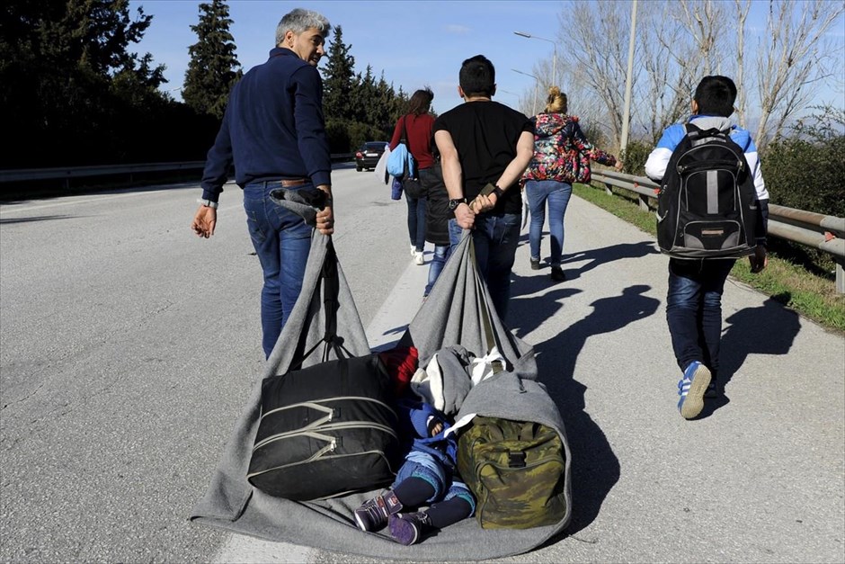 Στο δρόμο για τα σύνορα Ελλάδας - ΠΓΔΜ. Ένα παιδί κοιμάται σε μία κουβέρτα, την οποία τραβούν δύο άντρες, καθώς πλησιάζουν προς τα σύνορα Ελλάδας - ΠΓΔΜ, κοντά στην Ειδομένη. Κανένας Αφγανός δεν περνάει από τις 11 το πρωί από την ουδέτερη ζώνη Ελλάδας - ΠΓΔΜ, καθώς οι αρχές της γειτονικής χώρας απαγορεύουν πλέον τη διέλευσή τους. Γίνονται εξονυχιστικοί έλεγχοι εγγράφων σε όλους πρόσφυγες οι οποίοι μπορούν να συνεχίσουν το ταξίδι τους μόνο εάν έχουν ταυτότητα ή διαβατήριο, μαζί με το υπηρεσιακό σημείωμα των ελληνικών αρχών. Η νέα κατάσταση έχει δημιουργήσει το αδιαχώρητο στον καταυλισμό προσωρινής διαμονής προσφύγων στην Ειδομένη, όπου βρίσκονται περίπου 1.500 άτομα, ενώ άλλα 4.000 που αποβιβάστηκαν από 80 λεωφορεία που ήρθαν από Αθήνα αναμένουν στο βενζινάδικο, στο ύψος του Πολυκάστρου.