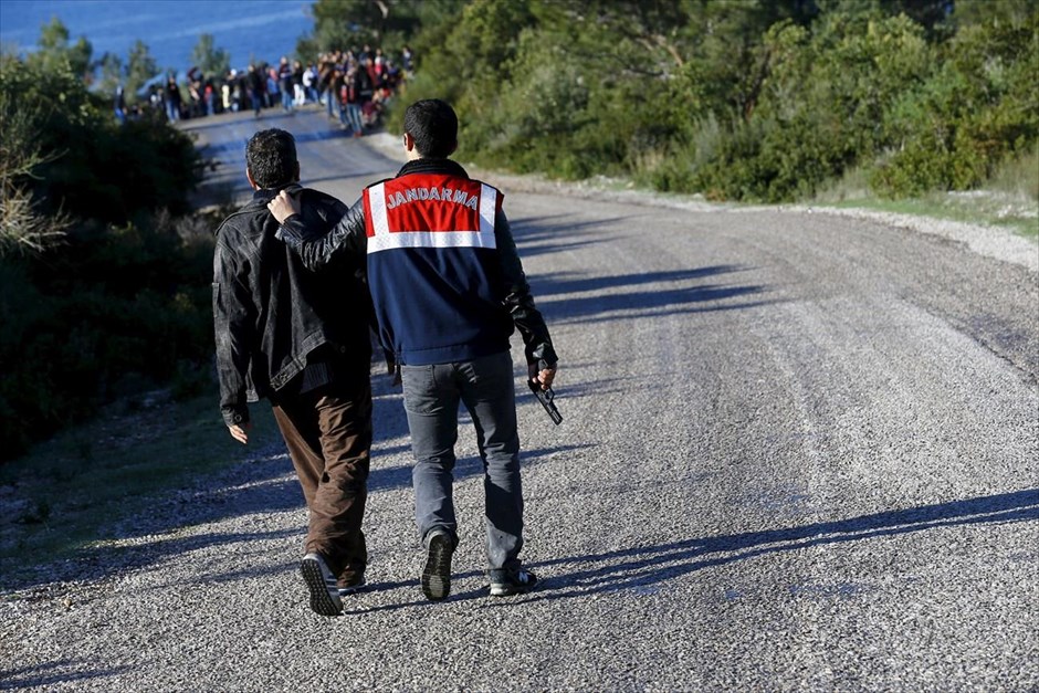 Σύλληψη διακινητή προσφύγων στο Δικελί. Τούρκος αστυνομικός έχει συλλάβει άντρα φερόμενο ως διακινητή προσφύγων, ενώ στο φόντο διακρίνονται Σύροι πρόσφυγες οι οποίοι ανέμεναν να αποπλεύσουν από παραλία της τουρκικής πόλης Δικελί, με προορισμό τη Λέσβο.