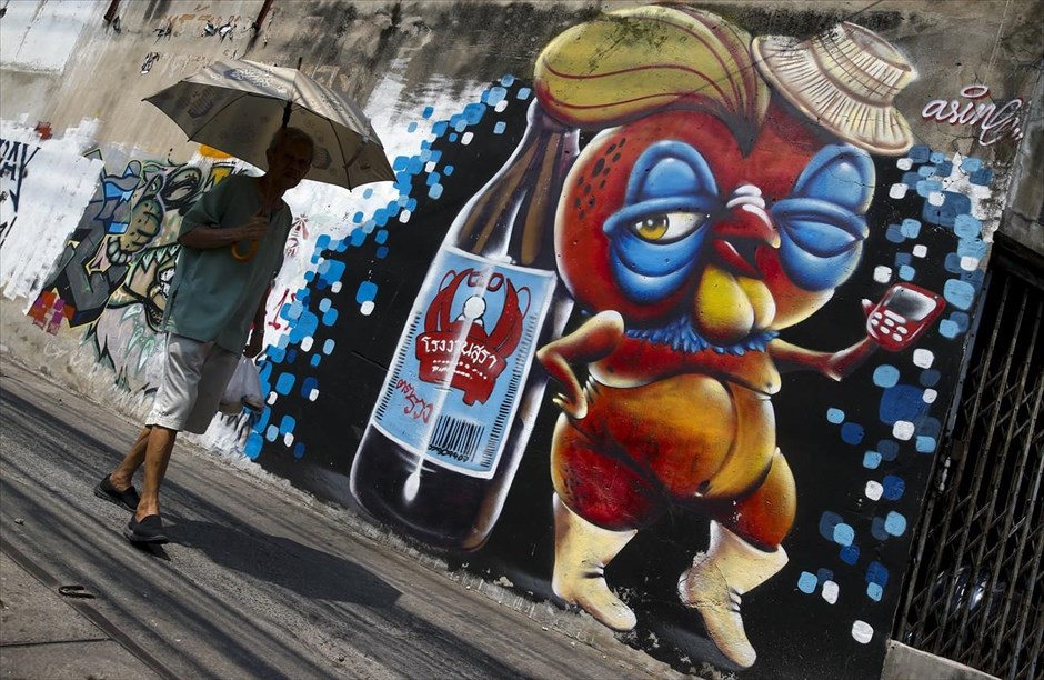 Γκράφιτι στην Μπανγκόκ. Ένας άνδρας περπατά σε δρόμο της&nbsp;Μπανγκόκ, δίπλα σε τοιχογραφία του καλλιτέχνη Asin Acid.