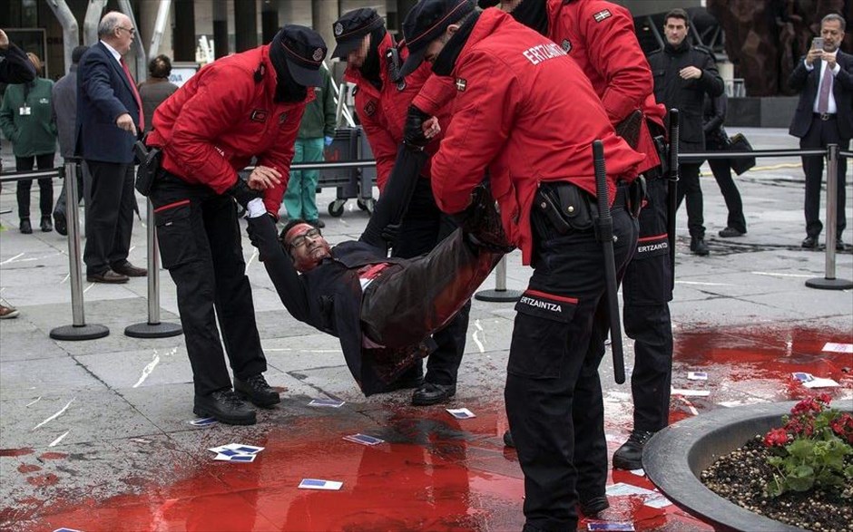Συλλήψεις στο Μπιλμπάο. Η αστυνομία των Βάσκων συλλαμβάνει διαδηλωτή καλυμμένο με ψεύτικο αίμα μπροστά από συνεδριακό κέντρο όπου συναντιούνται μέτοχοι της τράπεζας BBVA.