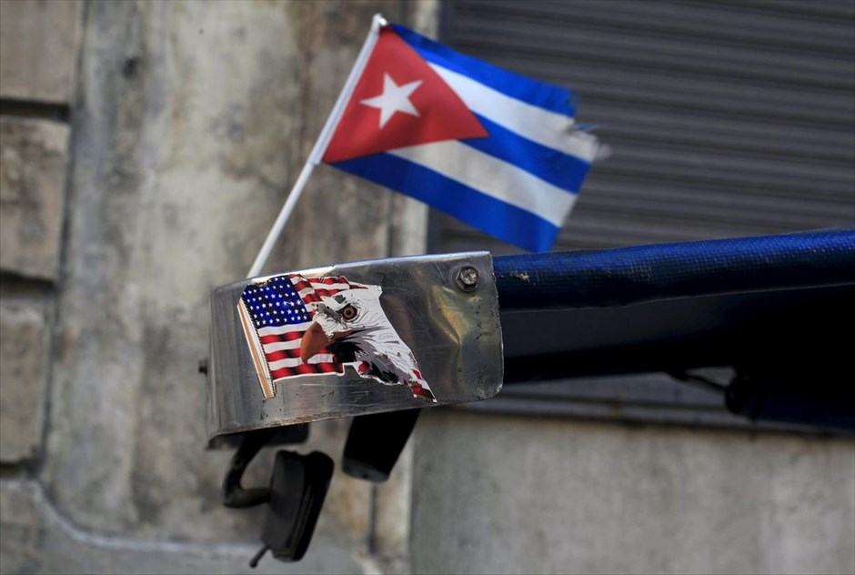 Κούβα - Αβάνα. Η σημαία της Κούβας ανεμίζει δίπλα σε αυτοκόλλητο με την αμερικανική σημεία στην οροφή τρικύκλου, στην Αβάνα.