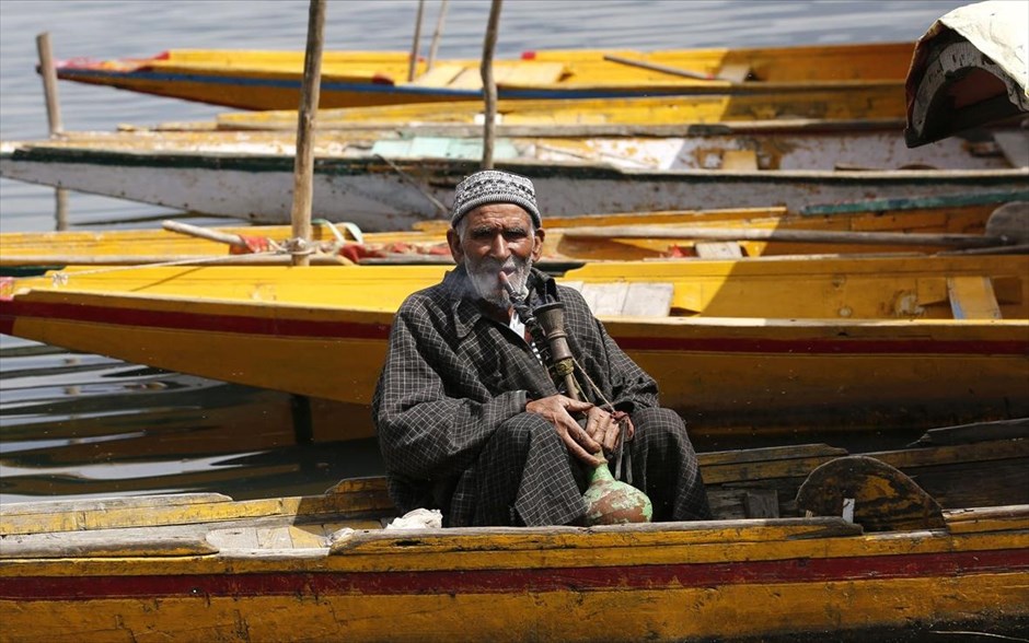 Καθημερινή ζωή στη Σριναγκάρ. Ένας άντρας καπνίζει μέσα στη βάρκα του, στη λίμνη Νταλ,&nbsp;τη&nbsp;θερινή&nbsp;πρωτεύουσα&nbsp;του ινδικού Κασμίρ.