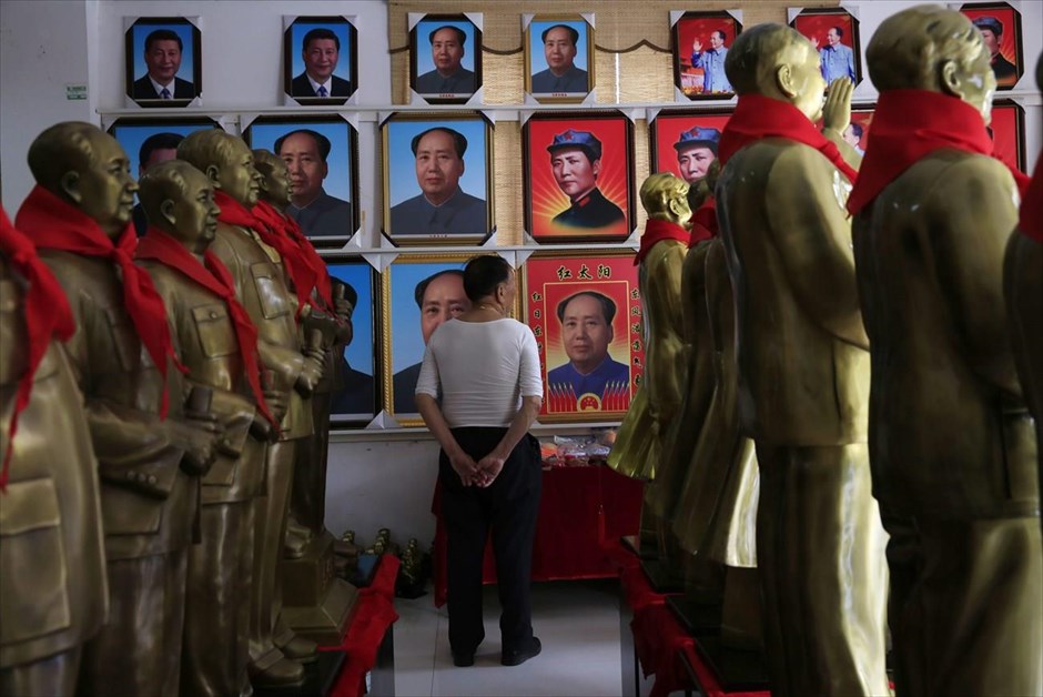 Κίνα: 50η επέτειος της Πολιτιστικής Επανάστασης. Ένας άντρας κοιτά πορτρέτα του ιδρυτής της Λαϊκής Δημοκρατίας της Κίνας, σε κατάστημα με σουβενίρ, στη γενέτειρα του Μάο Τσετούνγκ, Σαοσάν. Η πόλη αποτελεί πόλο έλξης χιλιάδων ανθρώπων, που στο πλαίσιο του «κόκκινου τουρισμού» επισκέπτονται περιοχές με μεγάλη ιστορική σημασία για την κινεζική επανάσταση.
