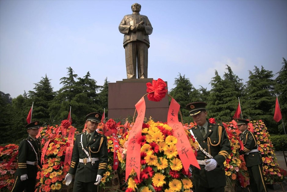Κίνα: 50η επέτειος της Πολιτιστικής Επανάστασης. Κινέζοι στρατιώτες τακτοποιούν τα λουλούδια που έχουν τοποθετηθεί στη βάση αγάλματος του Μάο, στο Σαοσάν. 