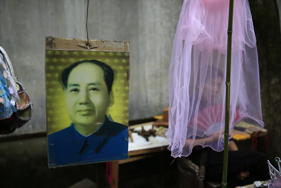 Κίνα: 50η επέτειος της Πολιτιστικής Επανάστασης. Πλανόδια πωλήτρια σουβενίρ στη γενέτειρα του Μάο.