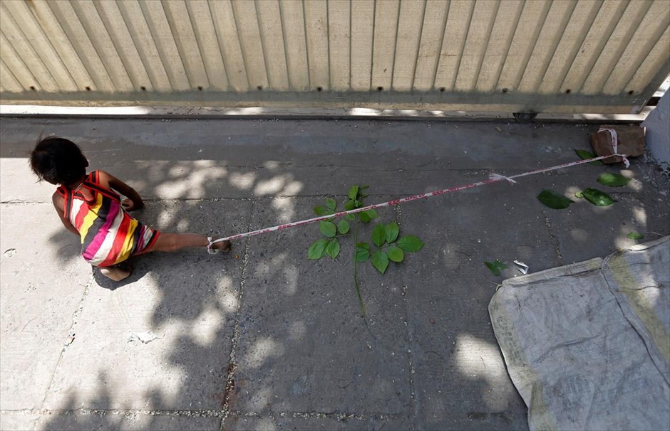 Δεμένη με σχοινί . Η ηλικίας 15 μηνών Σιβάνι είναι δεμένη με σχοινί από τον αστράγαλο, ενώ οι γονείς της εργάζονται, στο Αχμενταμπάντ της Ινδίας. Η μητέρα του κοριτσιού υποστηρίζει ότι δεν έχει άλλη επιλογή για να φυλάξει την κόρη της, όση ώρα αυτή και ο σύζυγός της εργάζονται σε εκσκαφές του εδάφους για την τοποθέτηση καλωδίων, κερδίζοντας 3,8 δολάρια την ημέρα ο καθένας. Περίπου 40 εκατομμύρια άτομα απασχολούνται στα έργα υποδομής των αναπτυσσόμενων ινδικών πόλεων. Σε αρκετές περιοχές της χώρας δεν αποτελούν σπάνιο θέαμα τα παιδιά που παίζουν στους δρόμους, καθώς οι γονείς τους μεταφέρουν τούβλα για την κατασκευή πολυτελών κατοικιών, ή σκάβουν για τη δημιουργία νέων δρόμων.