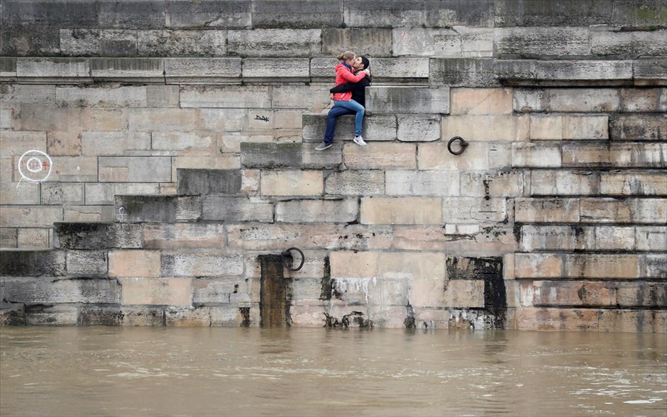 Πλημμύρες - Γαλλία. Ζευγάρι φιλιέται πάνω από τα φουσκώμενα νερά του Σηκουάνα.