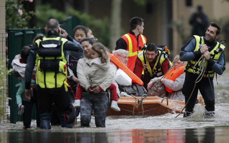 Πλημμύρες - Γαλλία. Γάλλοι πυροσβέστες βοηθάνε κατοίκους να φύγουν από τα πλημμυρισμένα σπίτια τους.