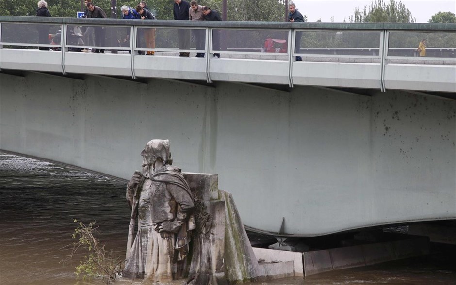 Πλημμύρες - Γαλλία. Άνθρωποι κοιτάνε το άγαλμα Zouave που έχει καλυφθεί με νερό.