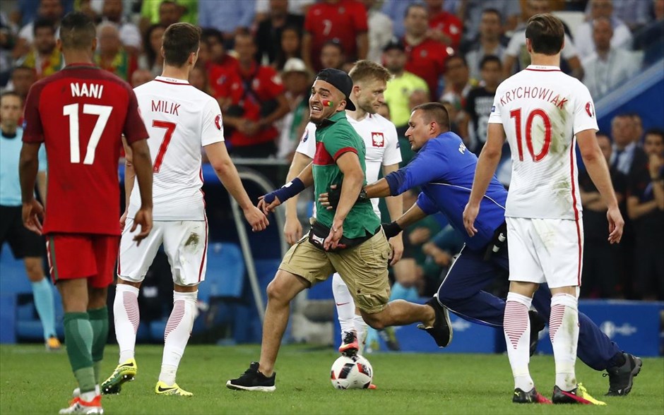 Πολωνία - Πορτογαλία. Άνδρας της ομάδας ασφαλείας κυνηγάει τον οπαδό που όρμησε στο γήπεδο την ώρα που ο αγώνας βρισκόταν σε εξέλιξη.