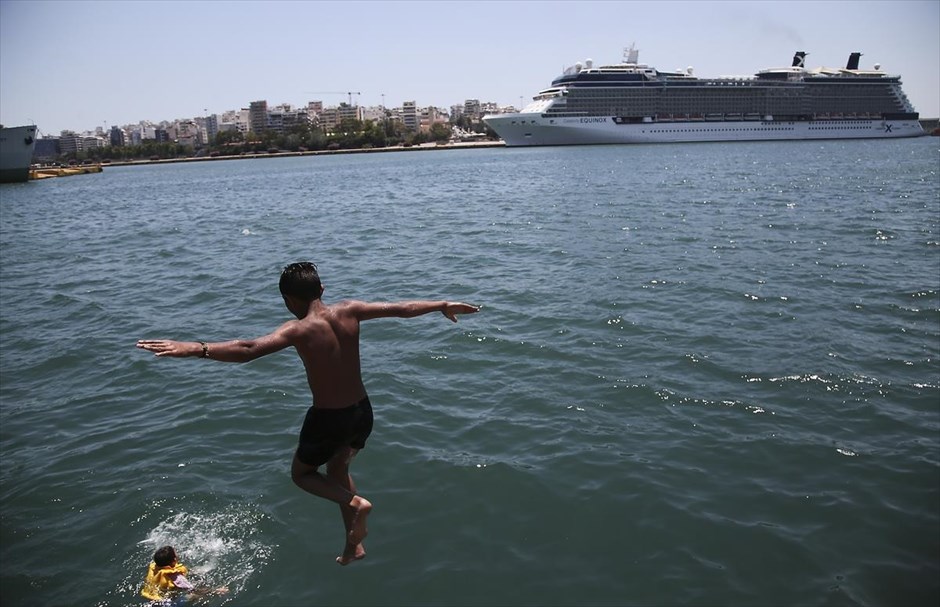 Βουτιές στο λιμάνι του Πειραιά. Προσφυγες και μετανάστες κολυμπάνε στο λιμάνι του Πειραιά, στην Αθήνα.