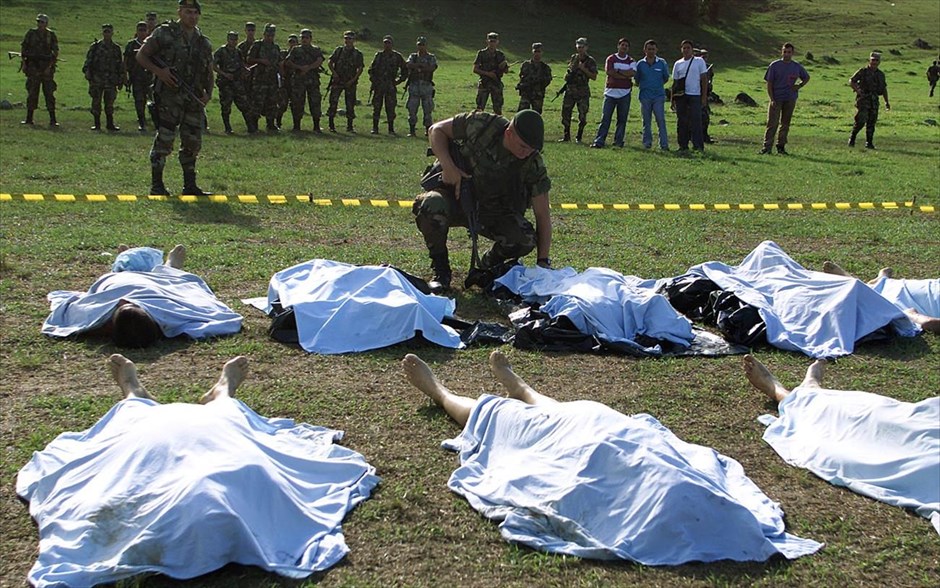 Κολομβία: 52 χρόνια ένοπλης σύγκρουσης κυβέρνησης και ανταρτών FARC. Κολομβιανός στρατιώτης κοιτά τις καλυμμένες σορούς ανταρτών FARC, που σκοτώθηκαν κατά τη διάρκεια σύγκρουσης στη Λα Πλάτα, στην επαρχία Χουίλα (12 Ιουλίου 2012).