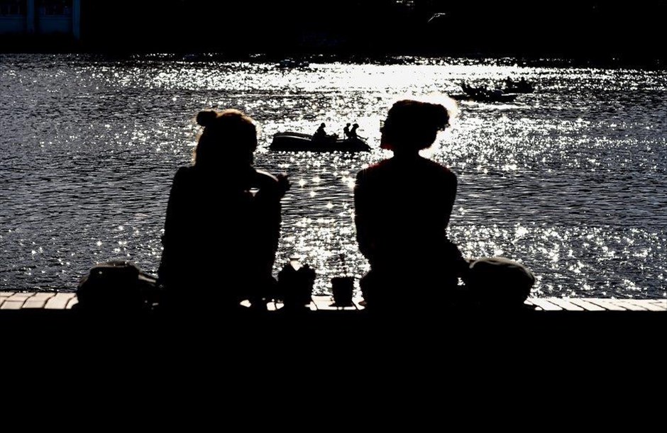 Βαρκάδα στην Πράγα. Δύο γυναίκες απολαμβάνουν τον ήλιο μπροστά στον ποταμό Μολδάβα, στην Πράγα.