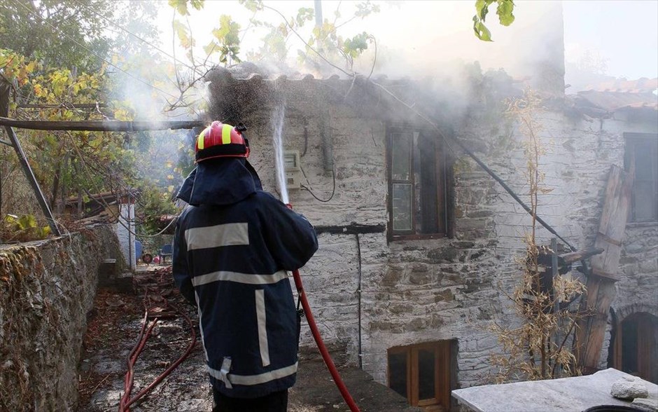 Πυρκαγιά στη Θάσο - Πυροσβεστική - Φωτιά. Πυροσβέστης επιχειρεί στην κατάσβεση σε σπίτι στο χωριό Ραχώνι.
