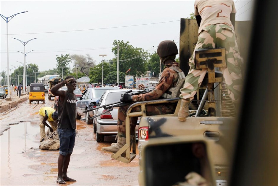 Νιγηρία - Μπόκο Χαράμ. Ένα αγόρι χαιρετά στρατιώτες στο Μαϊντουγκούρι.