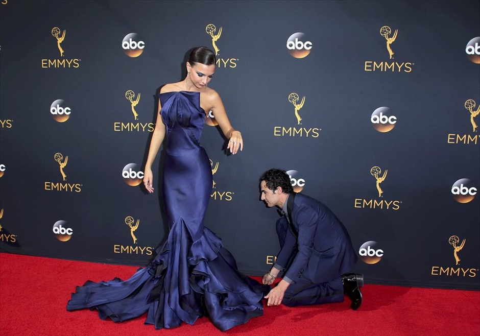 Βραβεία Emmy 2016. Ο σχεδιαστής μόδας Ζακ Πόζεν, από το «Project Runway» προσαρμόζει το φόρεμα του μοντέλου Έμιλι Ραταϊκόφσκι, κατά την άφιξή τους στο κόκκινο χαλί της 68ης τελετής απονομής των βραβείων Emmy, στο Λος Άντζελες.