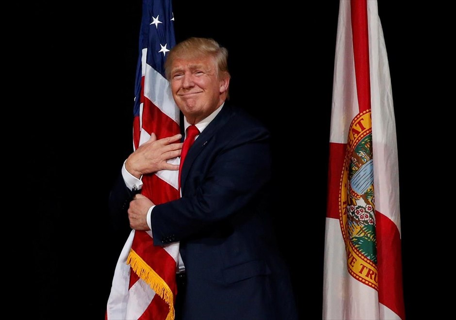 Προεκλογική συγκέντρωση του Τραμπ στη Φλόριντα . Ο υποψήφιος των Ρεπουμπλικανών για την προεδρία των ΗΠΑ Ντόναλντ Τραμπ αγκαλιάζει την αμερικανική σημαία, καθώς ετοιμάζεται να μιλήσει σε υποστηρικτές του, στην Τάμπα της Φλόριντα.