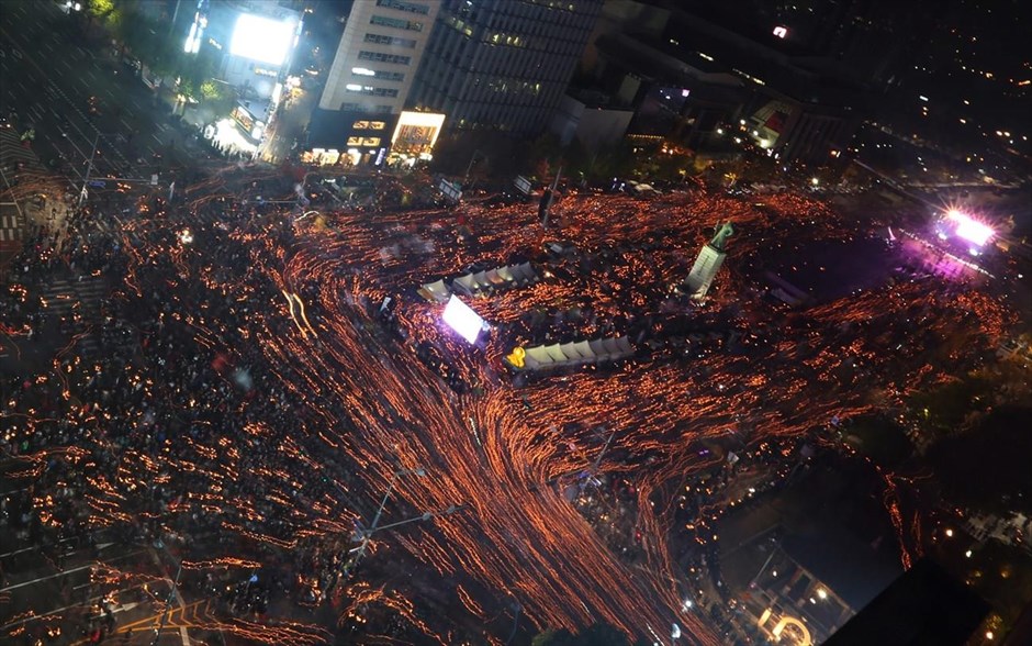 Διαμαρτυρία εναντίον της προέδρου της Ν. Κορέας στη Σεούλ. Στη φωτογραφία μακράς έκθεσης, απεικονίζονται Νοτιοκορεάτες διαδηλωτές καθώς συγκεντρώνονται για να διαμαρτυρηθούν ανάβοντας κεριά σε κεντρικό δρόμο της Σεούλ. Οι διαδηλωτές ζητούν την παραίτηση της προέδρου της χώρας Παρκ Γκέουν-χε, μετά την αποκάλυψη ότι επέτρεψε σε μια φίλη της, να αποκτήσει πρόσβαση σε απόρρητα κυβερνητικά έγγραφα.