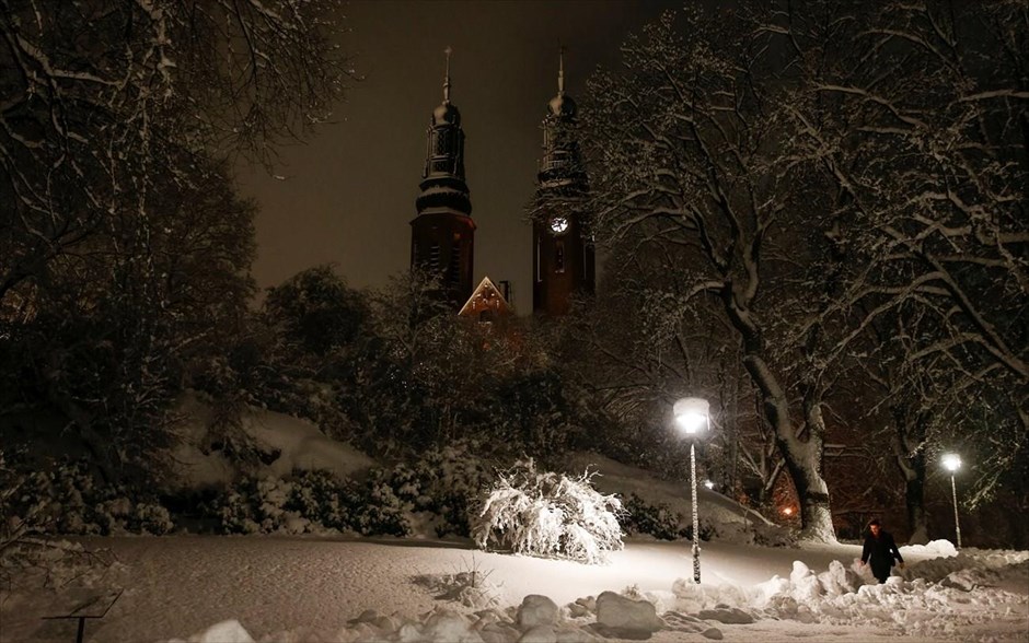 Χειμώνας στην Στοκχόλμη. Άνδρας περνα δίπλα από τη χιονισμένη εκκλησία Hogalids Kyrka, σε προάστιο της Στοκχόλμης. Η σουηδική πρωτεύουσα έχει ήδη σκεπαστεί με χιόνι και οι θερμοκρασίες είναι πολύ χαμηλές.