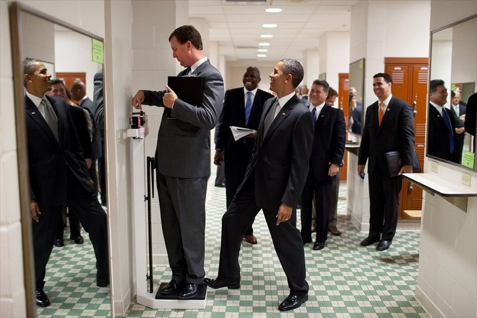 Μπαράκ Ομπάμα - Τα αγαπημένα καρέ του φωτογράφου του Ομπάμα. Ο Ομπάμα βάζει το πόδι του πάνω στη ζυγαριά, την ώρα που ο διευθυντής περιοδείας του Μάρβιν Νίκολσον ζυγίζεται, στα αποδυτήρια του Πανεπιστημίου του Τέξας, στο Όστιν (9 Αυγούστου 2010).