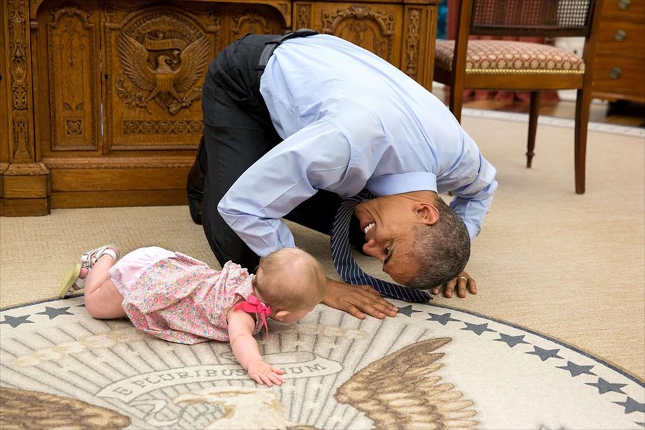 Μπαράκ Ομπάμα - Τα αγαπημένα καρέ του φωτογράφου του Ομπάμα. Ο αναπληρωτής σύμβουλος Εθνικής Ασφάλειας Μπεν Ρόουντς, μετά από επιμονή του προέδρου Μπαράκ Ομπάμα, έφερε την κόρη του Έλα στο Λευκό Οίκο. Καθώς μπουσουλούσε γύρω από το οβάλ γραφείο, ο Ομπάμα έπεσε στα γόνατα για να παίξει μαζί της (4 Ιουνίου 2005).
