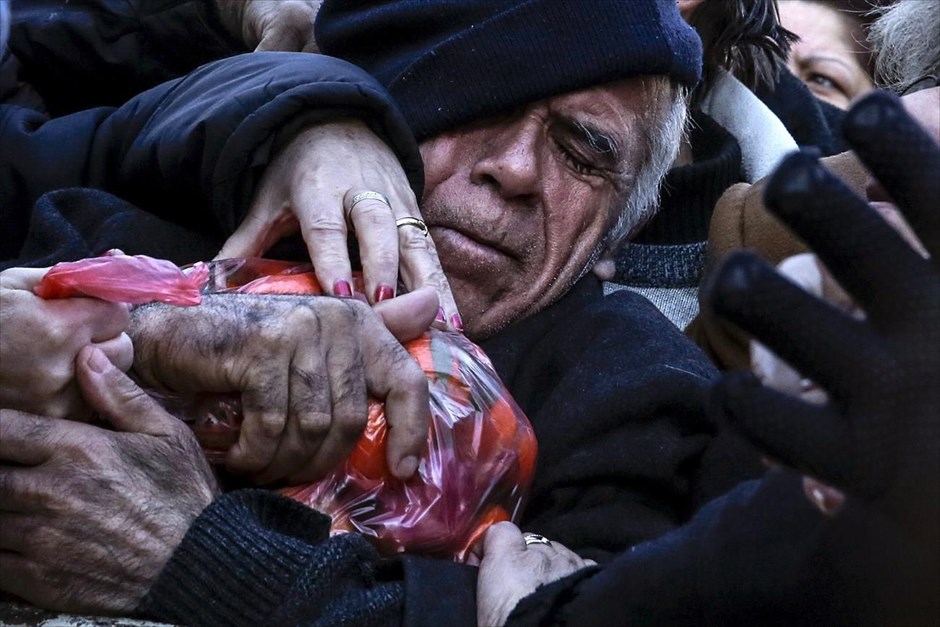POY2016. Ένας άντρας κρατά σφιχτά τη σακούλα με τα φρούτα που του διανεμήθηκε δωρεάν από παραγωγούς λαϊκών αγορών, στον Κολωνό (27 Ιανουαρίου).&nbsp;