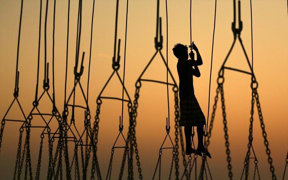 Προετοιμασίες για το Makhdoom Ali Mahimi. Αγόρι παίζει στη ρόδα του λούνα παρκ λίγο πριν ξεκινήσει το ετήσιο Φεστιβάλ Mahim, στην Βομβάη. Το φεστιβάλ διαρκεί 10 ημέρες και γίνεται προς τιμήν του Makhdoom Ali Mahimi, που αποτελεί μία από τις σημαντικότερες μορφές του Σουφισμού. Κατα τη διάρκεια του Makhdoom Ali Mahimi, οι πιστοί διασκέδαζουν με τις γιγάντιες ρόδες, τα τραινάκια και άλλα παιχνίδια στα λούνα παρκ που στήνονται ειδικά για την περίσταση.