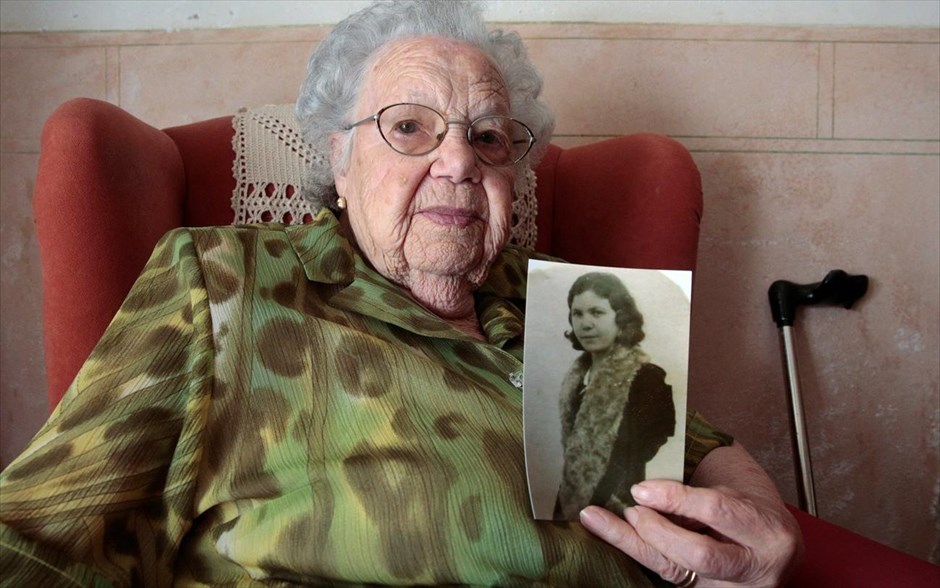 Ραφαέλα Πονς - Συμβουλές από τους υπεραιωνόβιους της Ισπανίας. Η Ραφαέλα Πονς, 102 χρονών, ποζάρει με μια φωτογραφία της από τα νιάτα της. Η κυρία Πονς ζει μόνη της στο νησί της Μινόρκα αλλά καθημερινά την επισκέπτεται η κόρη της. Είναι φανατική οπαδός της Ρεάλ Μαδρίτης και κάθε μέρα τρώει μια κουταλιά μέλι.