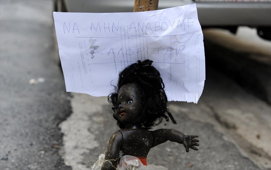 Πρωτότυπη διαμαρτυρία για την τιμή του πετρελαίου θέρμανσης. Ιδιότυπο μήνυμα που κρατά μια σχεδόν γυμνή έγχρωμη κούκλα σε είσοδο πολυκατοικίας στην Κυψέλη, γράφει: «Να μην ανάβουμε καλοριφέρ».Τα σχεδόν επτά χρόνια της κρίσης ανάγκασαν πολλούς ενοίκους πολυκατοικιών να αποφασίσουν την διακοπή της κεντρικής θέρμανσης λόγω της αδυναμίας τους να πληρώσουν τα αυξημένα κοινόχρηστα.Ο βαρύς χειμώνας που διανύουμε φέτος,επιδείνωσε την κατάσταση.