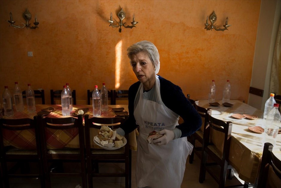 Ελλάδα - φτώχεια . Η συνταξιούχος εκπαιδευτικός και νυν εθελόντρια στα συσσίτια της εκκλησίας, Εύα Αγκισαλάκη, καθαρίζει τραπέζια.