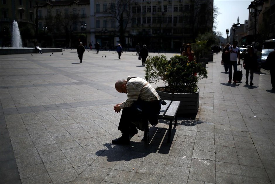 Στιγμιότυπο από το κέντρο της Αθήνας. Ένας άντρας κάθεται σε παγκάκι, στην πλατεία Κοτζιά, στο κέντρο της Αθήνας.