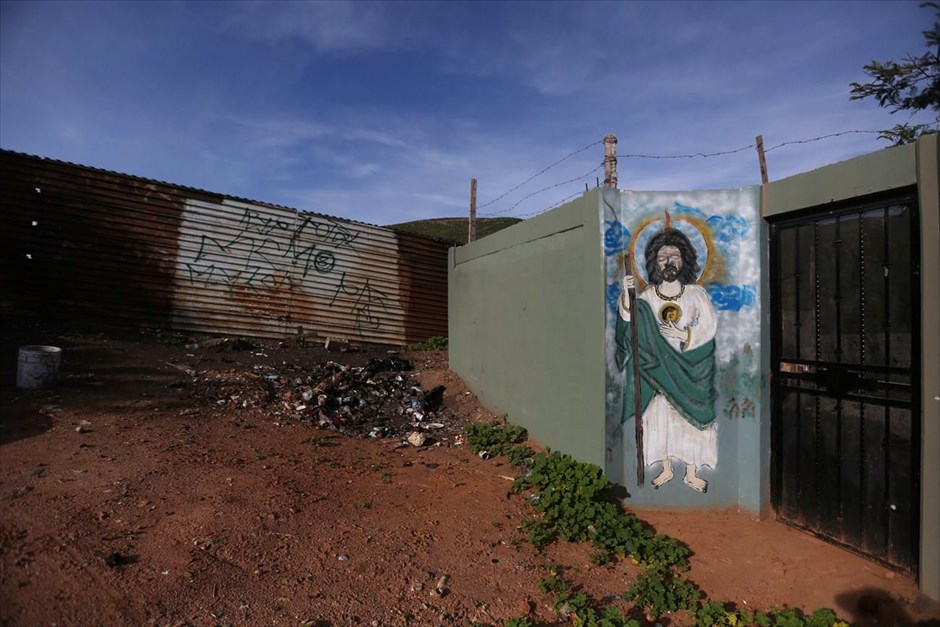 Μεξικό: Στη σκιά του φράχτη. Ζωγραφιά που απεικονίζει τον Ιησού διακρίνεται σε τοίχο κατοικίες δίπλα στον φράχτη που χωρίζει Μεξικό και ΗΠΑ.