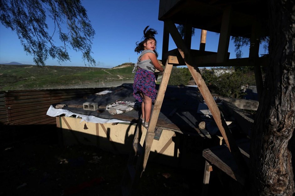 Μεξικό: Στη σκιά του φράχτη. Ένα κορίτσι ανεβαίνει σε μια σκάλα, κοντά στα σύνορα Μεξικού - ΗΠΑ.