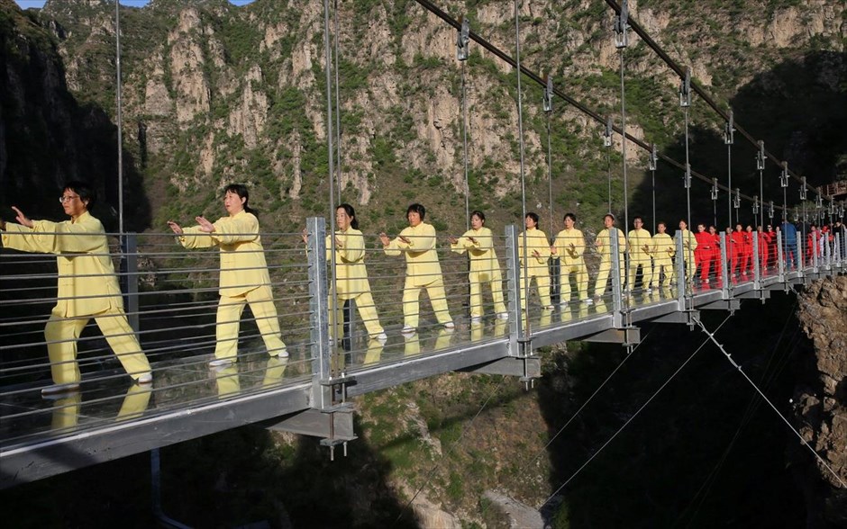 Πρωτότυπο μάθημα πολεμικών τεχνών . Κόσμος εξασκεί την πολεμική τέχνη του τάι τσι σε κρεμαστή γέφυρα του Πεκίνου, στο πλαίσιο εκδήλωσης τουριστικής προβολής. &nbsp;