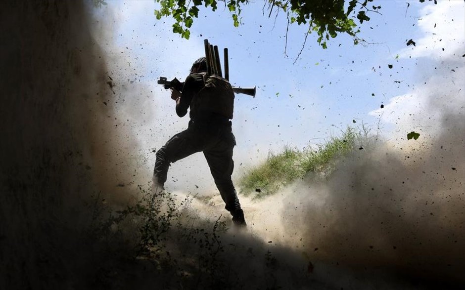 Στο μέτωπο του Αφγανιστάν . Αφγανός στρατιώτης διακρίνεται ανάμεσα σε&nbsp;μπάζα και καπνό να χρησιμοποιεί το όπλο του έπειτα από επίθεση που δέχτηκε ο στρατός από τους μαχητές του Ισλαμικού Κράτους στην επαρχία Νανγκαρχάρ στο Αφγανιστάν. Η περιοχή Νανγκαρχάρ, που συνορεύει με το Πακιστάν, είναι μία από τις πιο ταραχώδεις περιοχές του Αφγανιστάν, καθώς χρησιμοποιείται ως οχυρό του Ισλαμικού Κράτους ενώ συγκεντρώνει και σημαντική παρουσία των Ταλιμπάν. &nbsp;